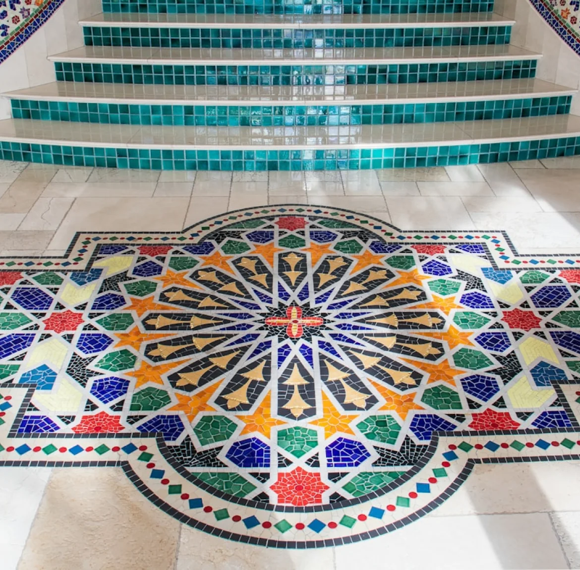 A decorative mosaic medallion set into a tiled indoor floor